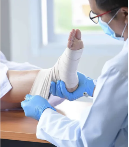 Therapist applying supportive bandaging to a patient's ankle